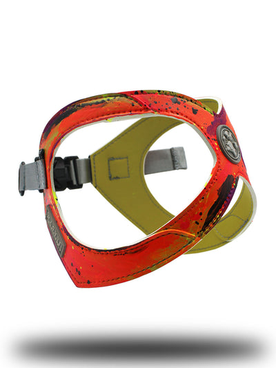 Hand painted orange and pink vegan leather dog harness floating above the floor on a photo set.