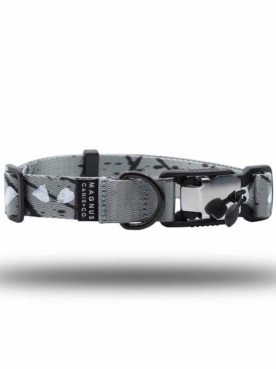 A MAGNUS Canis silver printed pattern strap dog collar with a magnetic buckle laying horizontally with a white background.