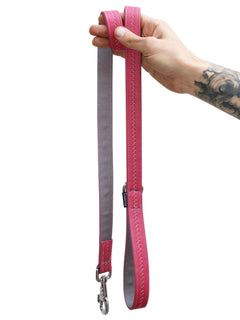 Pink vegan leather dog leash by MAGNUS Canis that is being held vertically.