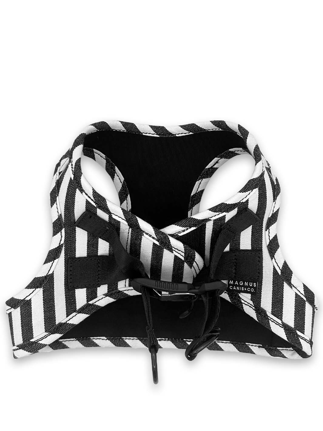 A white and black striped denim dog harness laying on a white surface.